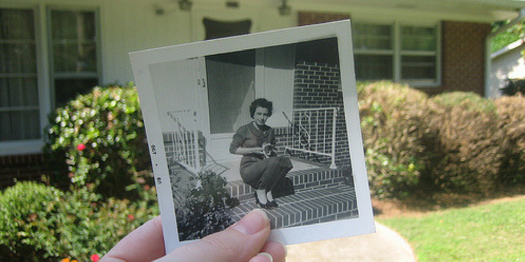 Photo held in front of house that overlaps with a present day scene